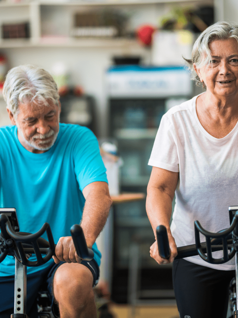 Seniors utilizing low-impact stationary cycling to improve mobility and avoid stress on joints. 